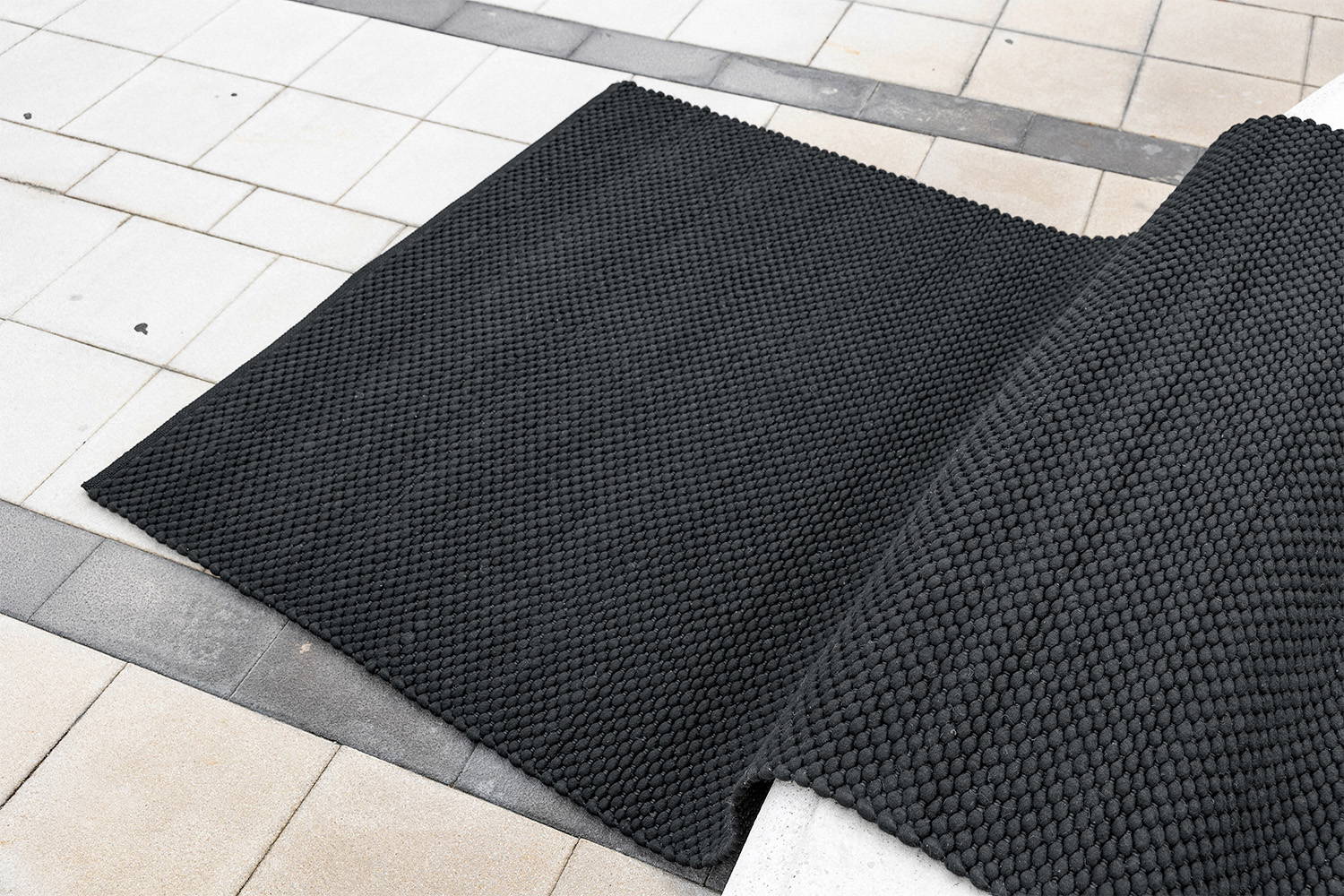 The Dakar rug pictured on a stone floor.