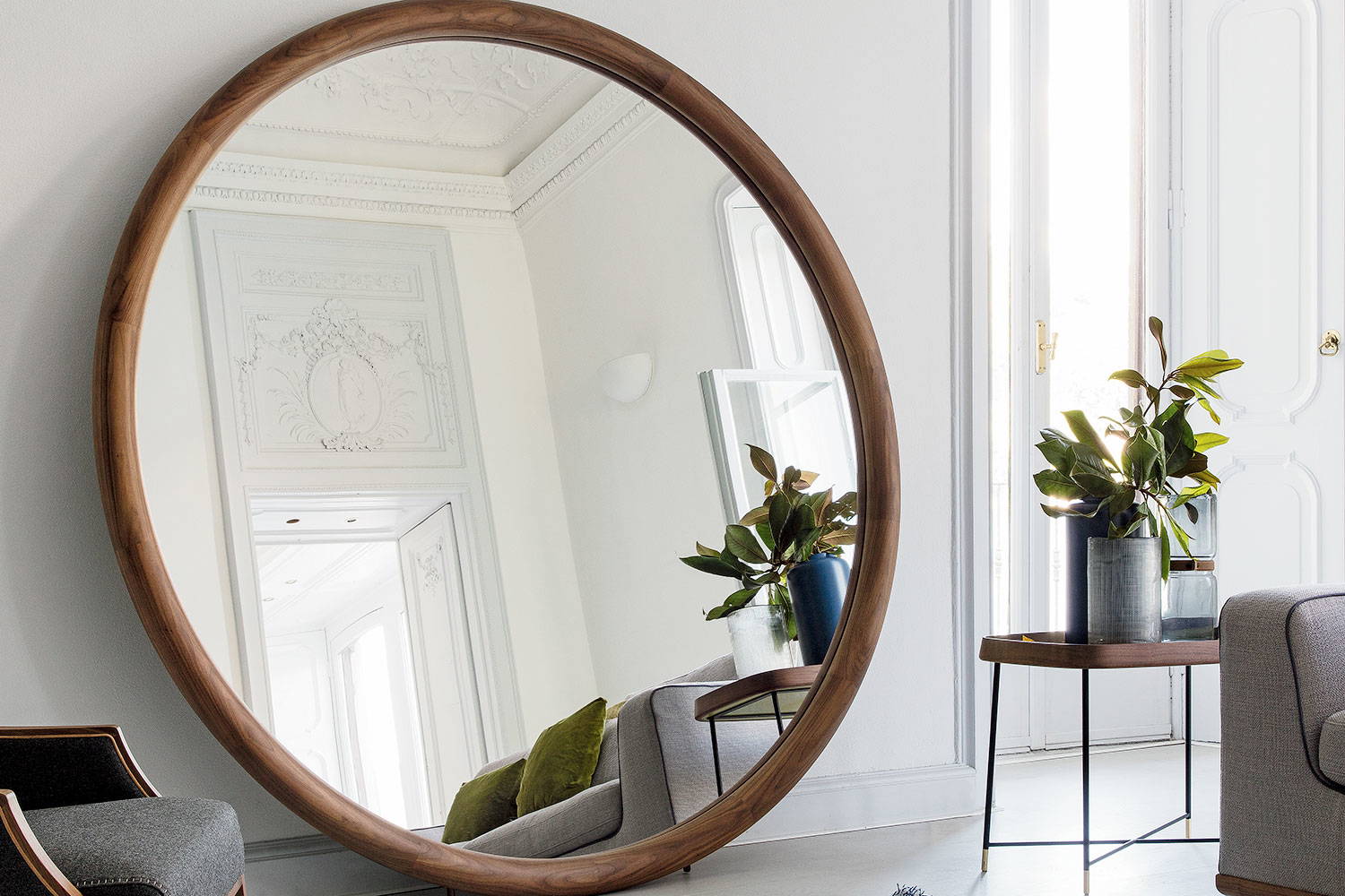 Giove mirror leaning against the wall in a living room setting by Porada