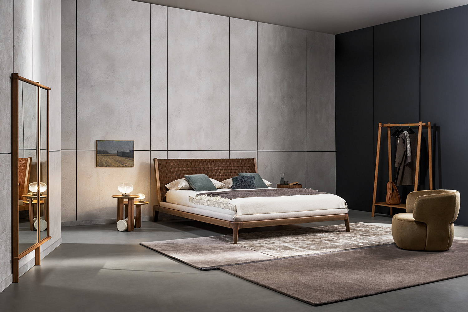 The Honeymoon bed with the Doge armchair, Isola mirror, and Isola clothes rack