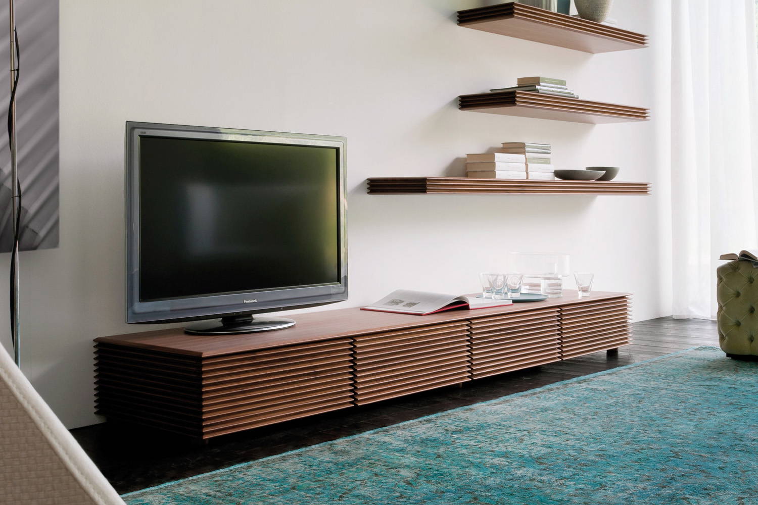 Riga TV stand in living room setting with Alcide pouf by Porada