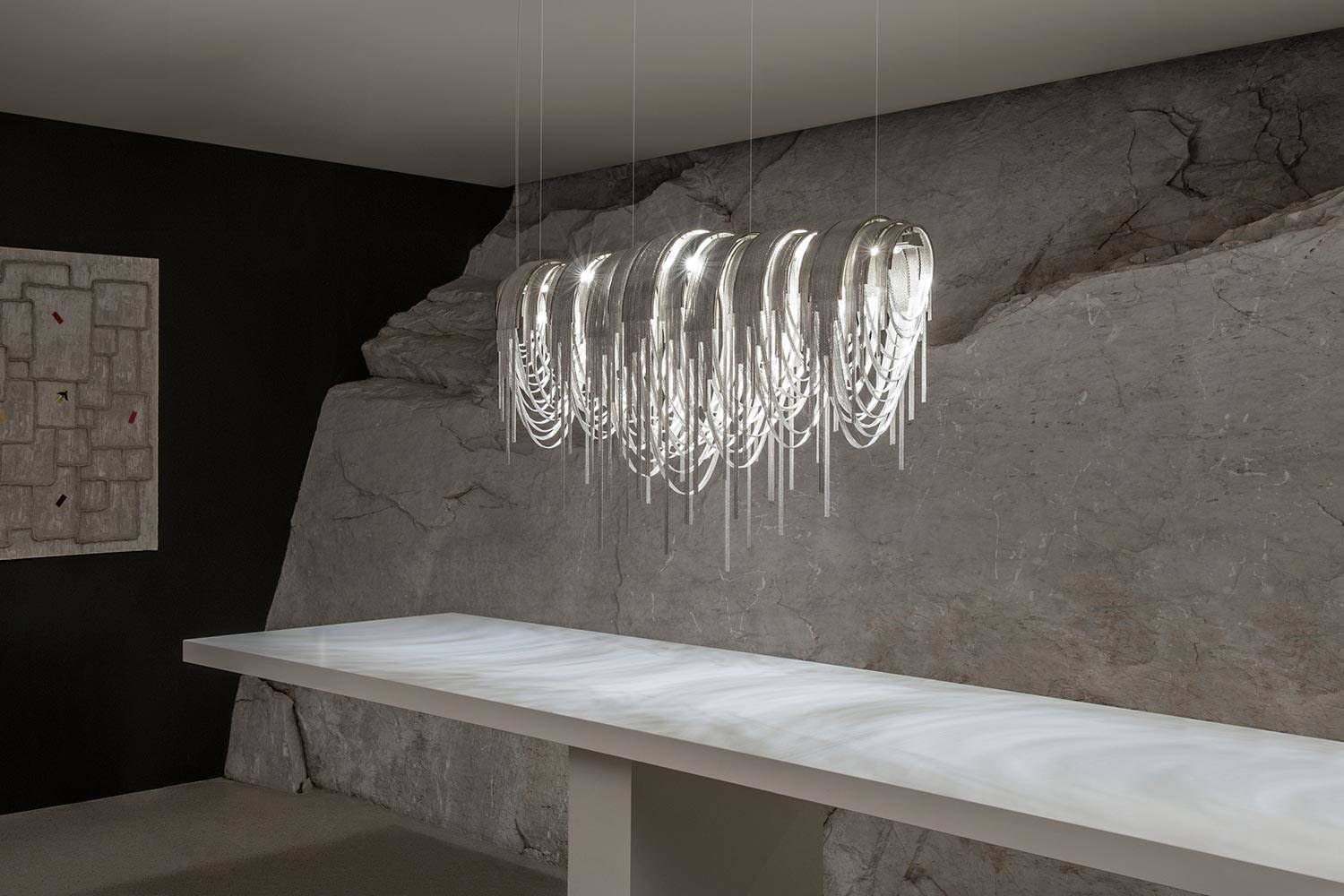 Volver linear chandelier by Terzani in a dining area setting 